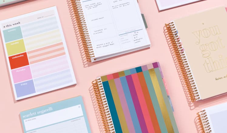 Coiled guided journals and notebooks on a table.